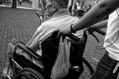 carer pushing man in wheelchair